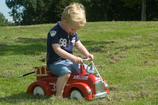 De loopauto heeft metalen wielen met rubberen banden.